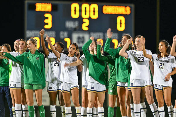 Women's soccer team in front of scoreboard